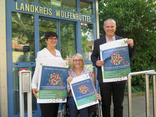 Projektleiterin Heintzen, die Schwerbehinderten-Vertrauensperson Brentrop und Kreisrat Retzki halten Plakate für den Inklusionsworkshop hoch.