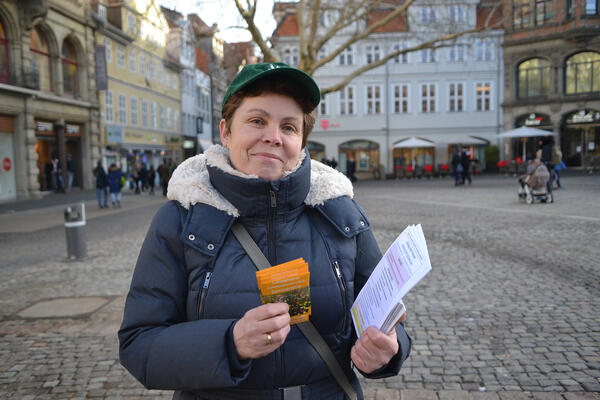 Meike Schreiber steht auf dem Kohlmarkt in Braunschweig. Sie hat Flugblätter in der Hand.