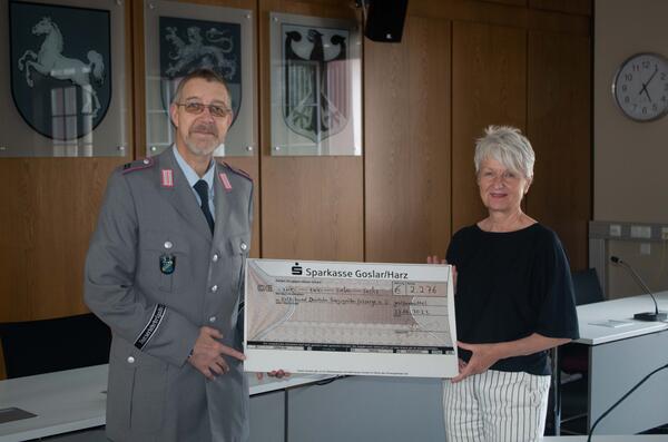 Landrätin Christiana Steinbrügge bei der Übergabe der Spenden für den Volksbund Deutsche Kriegsgräberfürsorge e.V. Sie überreicht einen großen Scheck.