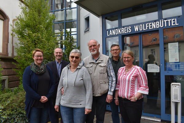 Eine Gruppe Menschen steht vor einem Geb�ude.