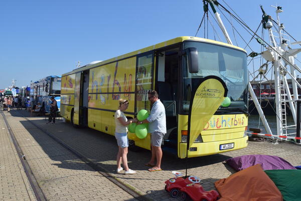 Der Bücherbus aus dem Landkreis Wolfenbüttel ist zu sehen. Davor stehen zwei Personen. 