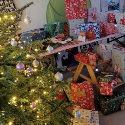 Ein geschmückter Weihnachtsbaum, im Hintergrund sind Geschenke.