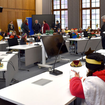 Sternsingerinnen und Sternsinger sitzen zusammen im Großen Sitzungsaal der Kreisverwaltung.