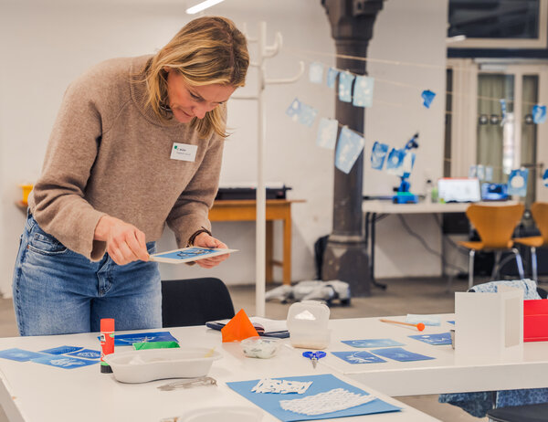Zu sehen ist eine Lehrerin, die Cyanotypien, die im Anschluss digital animiert werden, erstellt.