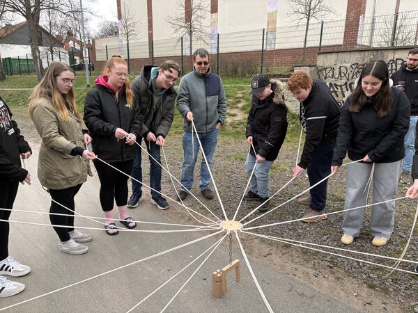 Eine Gruppe Menschen spielt ein gemeinsames Spiel. Die Menschen machen eine Jugendleiterausbildung. Sie testen Spiele, die sie in der Ausbildung kennengelernt haben.