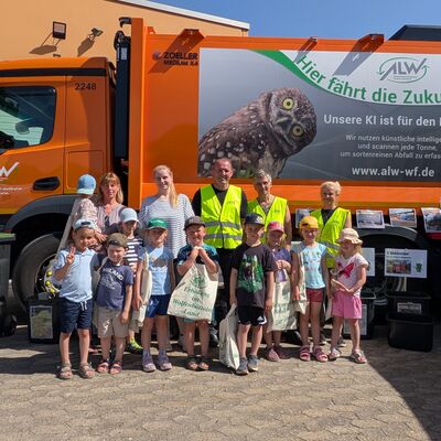 Gruppenbild von Kita-Kindern, Fachleuten und Erziehern vor einem M�llwagen.