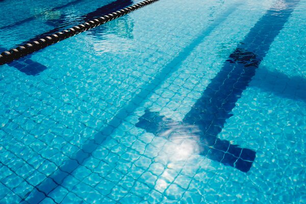 Nahaufnahme Schwimmbecken. Man sieht Wasser und die Fliesen im Pool.