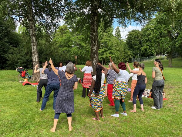 Eine Gruppe von Menschen tanzen in einem Park.