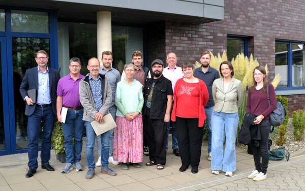 Zw�lf Menschen auf einem Gruppenfoto vor einem Backsteingeb�ude. Die Menschen besuchten die Auftaktveranstaltung Starkregen-Vorsorgekonzept am 10.09.2026 beim WWL (v.l.n.r.): Marko Kelb (Samtgemeinde Sickte), Stefan Str�mpel (Stadt K�nigslutter), Thomas Schaaf (Gemeinde Cremlingen), Nils Stanko (WWL), Marion Senger (Landwirtschaftskammer), Lars Kr�ger (Gemeinde Lehre), Maximilian Lorbeer (Stadt K�nigslutter), Christian Siemon (HGN), Sandra Ulbricht (WWL), Leo Letz (HGN), Kristina E� (Landkreis Wolfenb�ttel), Kimberly Rook (Landkreis Wolfenb�ttel).